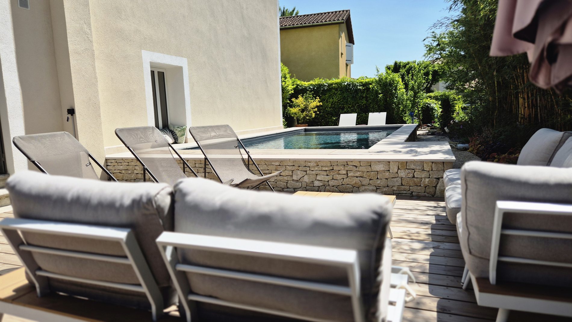 Piscine surélevée construite avec des panneaux modulaires Aquafeat, offrant une structure solide et durable pour un bassin hors-sol. L’ensemble est entouré d’un mur en pierre d’Eyzahut maçonné avec une finition en appareillage pierre sèche, assurant une parfaite intégration paysagère et une esthétique naturelle. La couverture du bassin est assurée par une bâche automatique immergée Aquagard, garantissant sécurité, protection et confort d’utilisation. À proximité immédiate, une terrasse contemporaine repose sur un lambourdage en structure métallique Terrassteel, avec un platelage en lames de bambou, matériau écologique et résistant. Aménagement extérieur complet alliant technicité, durabilité et design. Dupré la Tour piscine et paysage / Livron sur Drôme / Valence / Drôme Ardèche / paysagiste pisciniste