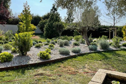 Réfection complète d’un jardin avec création d’un ensemble de massifs paysagers structurés et harmonieux. Les massifs sont composés de végétaux adaptés au climat local, mêlant persistants, vivaces, graminées et couvre-sols, pour un rendu à la fois esthétique, durable et facile d’entretien. Le travail de composition met en valeur les volumes, les textures et les couleurs selon les saisons. L’aménagement intègre également un paillage minéral ou organique selon les zones, assurant la gestion de l’humidité du sol et la limitation des adventices. Réalisation par un paysagiste professionnel pour sublimer l’espace extérieur avec une fontaine à poisson Valence Drôme Ardèche Rhône Alpes Paysagiste Pisciniste Dupré la Tour
