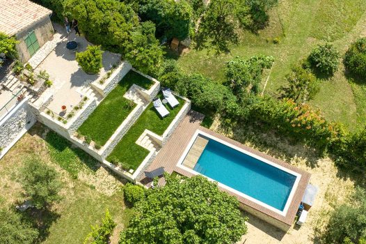Réfection complète d’un jardin paysager comprenant la réalisation d’une piscine surélevée en structure modulaire Aquafeat, offrant robustesse et durabilité. Autour du bassin, une terrasse contemporaine est installée sur une structure métallique Terrassteel, supportant un platelage résistant et esthétique. L’aménagement est complété par la construction de plusieurs murs en pierre d’Eyzahut, maçonnés et jointés à la chaux avec un sable jaune, pour un rendu authentique rappelant l’appareillage en pierre sèche traditionnel. Ce projet combine savoir-faire paysagiste, techniques de construction modernes et intégration harmonieuse dans l’environnement naturel. Dupré la Tour / Drôme Ardèche / Paysagiste / Valence / Pisciniste