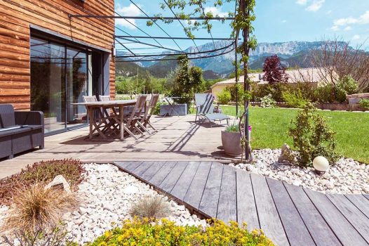 Création d’un espace bien-être extérieur avec l’installation d’un spa encastré à hauteur du sol, harmonieusement intégré dans un jardin paysager. Le spa est bordé par une terrasse en lames de bambou posée sur une structure métallique Terrassteel, assurant durabilité, résistance à l’humidité et finition soignée. Un mur en pierre naturelle vient structurer l’espace et renforcer l’ambiance authentique et chaleureuse. Des massifs paysagers complètent l’ensemble, avec notamment un olivier majestueux en élément central, apportant une touche méditerranéenne à la composition. Aménagement alliant confort, esthétisme et techniques modernes de construction extérieure. Ce projet illustre le savoir-faire d’un paysagiste et pisciniste en région Rhône-Alpes, intervenant à Valence, dans la Drôme et en Ardèche, pour des réalisations harmonieuses et techniques mêlant confort, tradition et modernité.