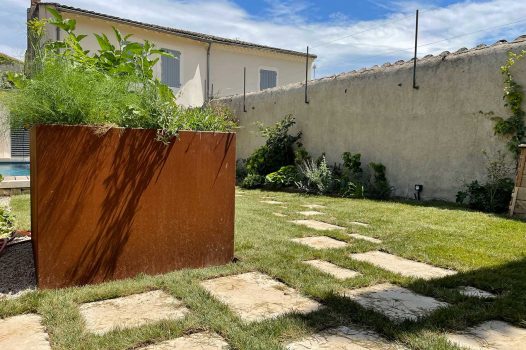 Piscine surélevée construite avec des panneaux modulaires Aquafeat, intégrée dans un petit jardin urbain à Saint-Péray, en Ardèche. Le bassin est habillé de murs en pierre d’Eyzahut, maçonnés avec un rendu pierre sèche, pour une finition naturelle et élégante parfaitement adaptée à l’environnement restreint. Ce type de construction allie compacité, robustesse et esthétisme, idéal pour les aménagements paysagers en zone urbaine. L'utilisation de matériaux durables comme les panneaux Aquafeat et la pierre locale valorise le patrimoine tout en garantissant un bassin fonctionnel et harmonieux dans un cadre réduit. Paysagiste Pisciniste Valence Drôme Ardèche Région rhone alpes
