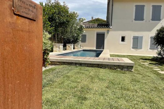 Piscine surélevée construite avec des panneaux modulaires Aquafeat, intégrée dans un petit jardin urbain à Saint-Péray, en Ardèche. Le bassin est habillé de murs en pierre d’Eyzahut, maçonnés avec un rendu pierre sèche, pour une finition naturelle et élégante parfaitement adaptée à l’environnement restreint. Ce type de construction allie compacité, robustesse et esthétisme, idéal pour les aménagements paysagers en zone urbaine. L'utilisation de matériaux durables comme les panneaux Aquafeat et la pierre locale valorise le patrimoine tout en garantissant un bassin fonctionnel et harmonieux dans un cadre réduit. Paysagiste Pisciniste Valence Drôme Ardèche Région rhone alpes