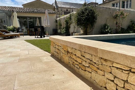 Piscine surélevée construite avec des panneaux modulaires Aquafeat, intégrée dans un petit jardin urbain à Saint-Péray, en Ardèche. Le bassin est habillé de murs en pierre d’Eyzahut, maçonnés avec un rendu pierre sèche, pour une finition naturelle et élégante parfaitement adaptée à l’environnement restreint. Ce type de construction allie compacité, robustesse et esthétisme, idéal pour les aménagements paysagers en zone urbaine. L'utilisation de matériaux durables comme les panneaux Aquafeat et la pierre locale valorise le patrimoine tout en garantissant un bassin fonctionnel et harmonieux dans un cadre réduit. Paysagiste Pisciniste Valence Drôme Ardèche Région rhone alpes