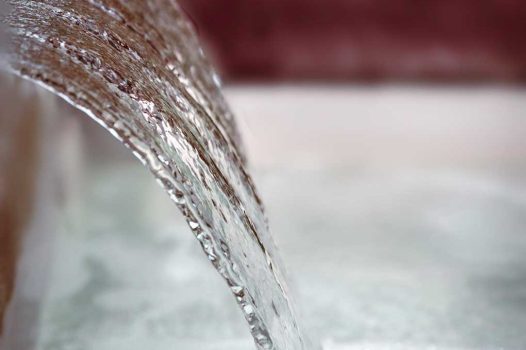 Création d’un espace bien-être extérieur avec l’installation d’un spa encastré à hauteur du sol, harmonieusement intégré dans un jardin paysager. Le spa est bordé par une terrasse en lames de bambou posée sur une structure métallique Terrassteel, assurant durabilité, résistance à l’humidité et finition soignée. Un mur en pierre naturelle vient structurer l’espace et renforcer l’ambiance authentique et chaleureuse. Des massifs paysagers complètent l’ensemble, avec notamment un olivier majestueux en élément central, apportant une touche méditerranéenne à la composition. Aménagement alliant confort, esthétisme et techniques modernes de construction extérieure. Ce projet illustre le savoir-faire d’un paysagiste et pisciniste en région Rhône-Alpes, intervenant à Valence, dans la Drôme et en Ardèche, pour des réalisations harmonieuses et techniques mêlant confort, tradition et modernité.