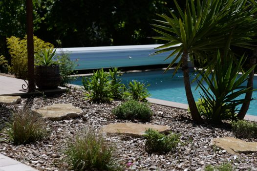 Piscine avec couverture de mise en sécurité avec création de massif mur en pierre et pas japonais Dupré la Tour piscine et paysage Drôme